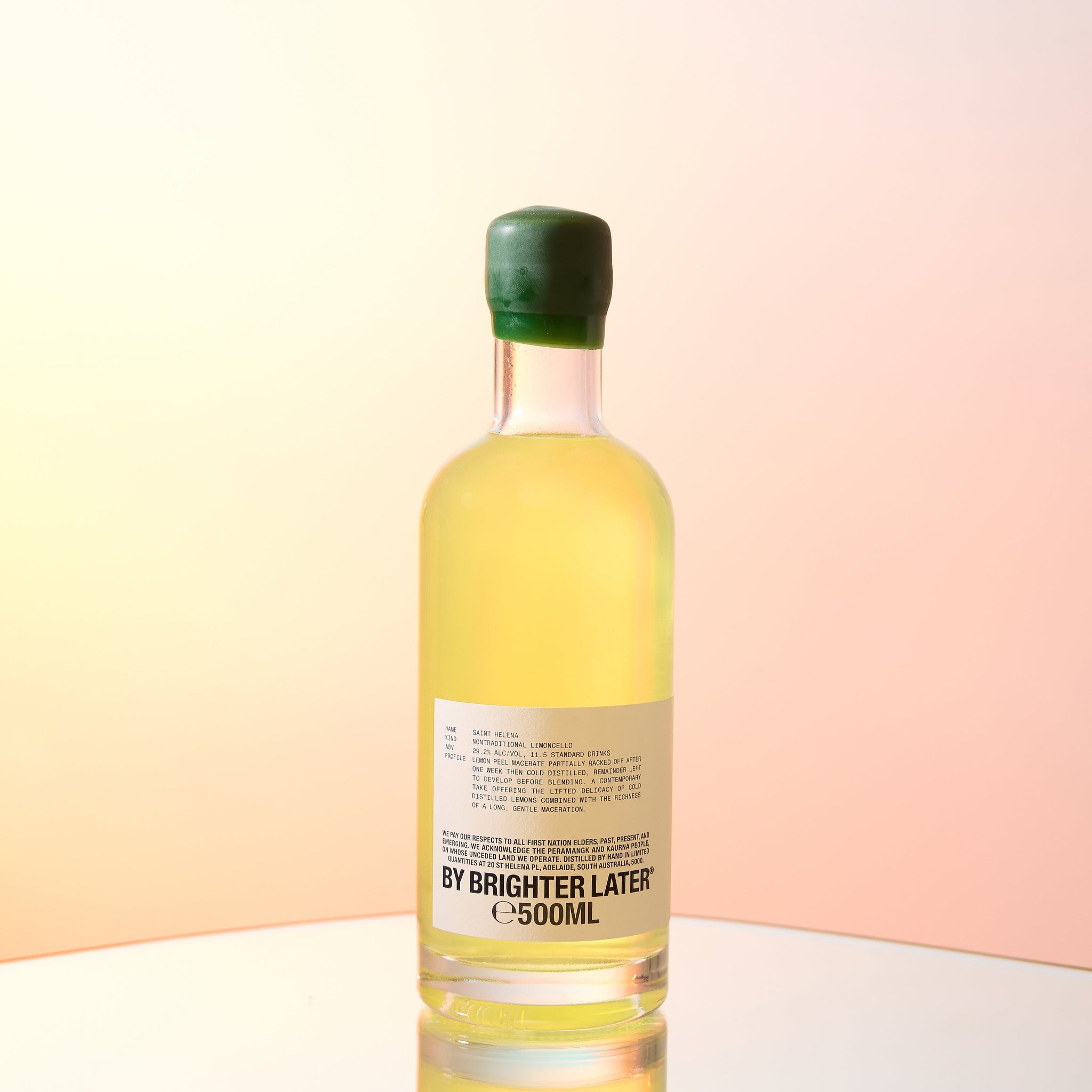 A bottle of limoncello on sunset and blue studio background.