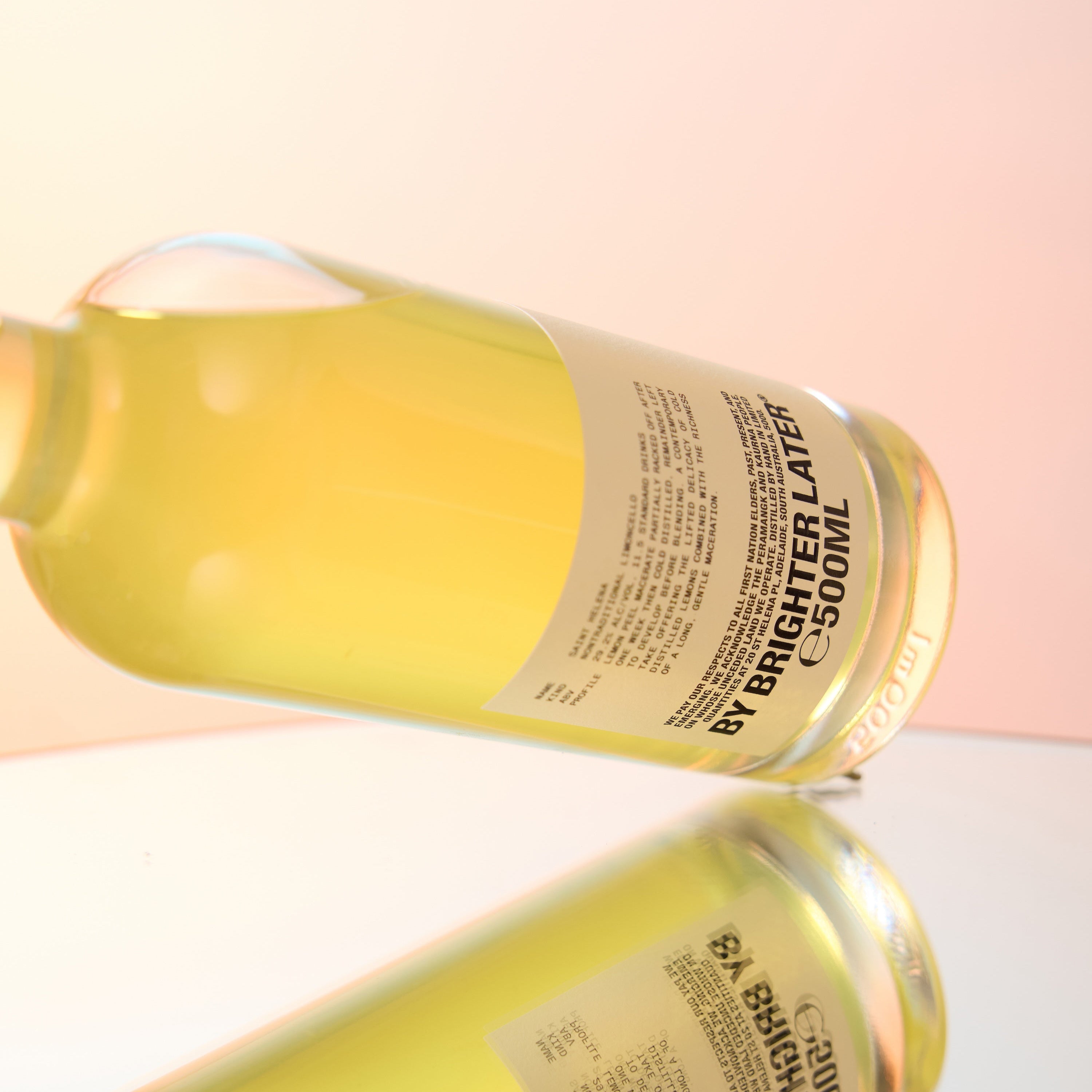 A bottle of coffee liqueur on a sunset orange gradient studio background.