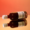 A bottle of coffee liqueur on its side on a sunset orange background.
